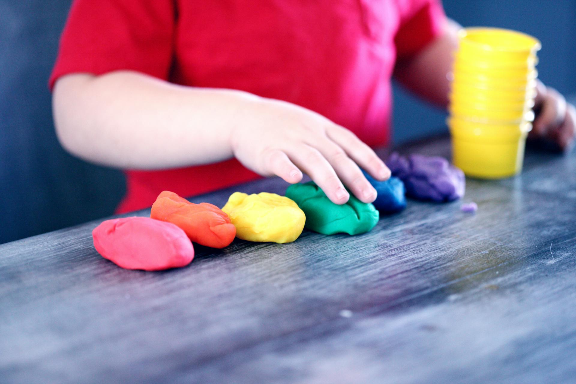 Image of a child playing with clay on a table